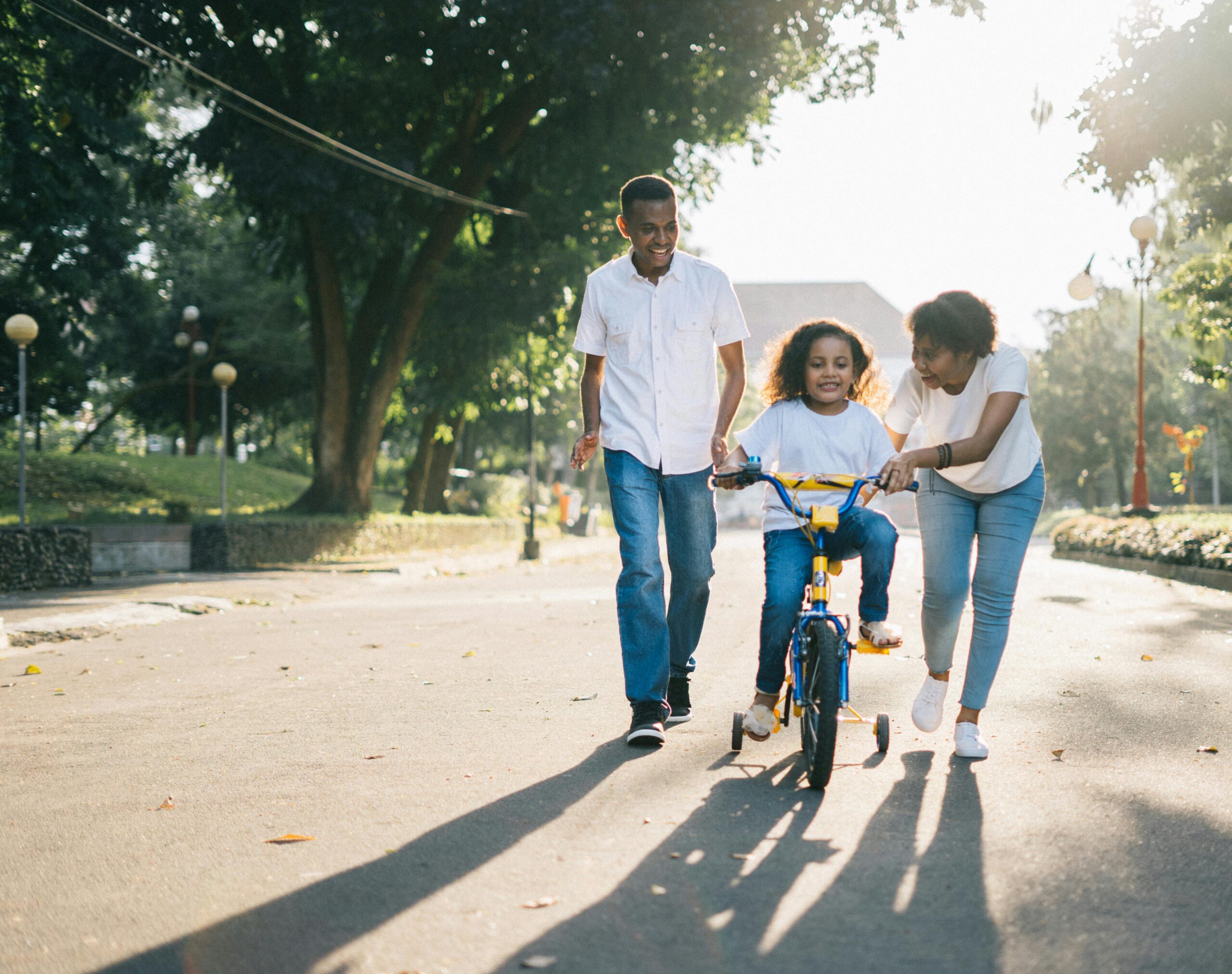 Photo by Agung Pandit Wiguna: https://www.pexels.com/photo/man-standing-beside-his-wife-teaching-their-child-how-to-ride-bicycle-1128318/