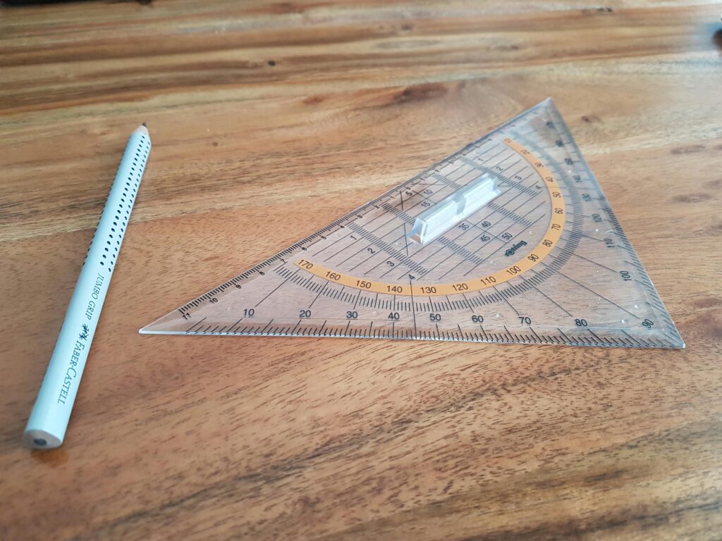 Photo by Chaos wolf: https://www.pexels.com/photo/gray-pencil-and-triangular-ruler-on-brown-wooden-surface-376689/